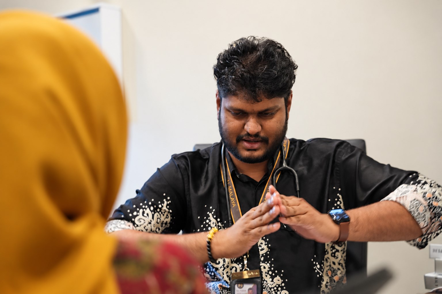 Dr. Tamil demonstrating a hand position during a consultation